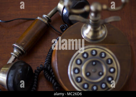 Vintage telefono su un tavolo di legno con il telefono verso il basso. Vista superiore Foto Stock