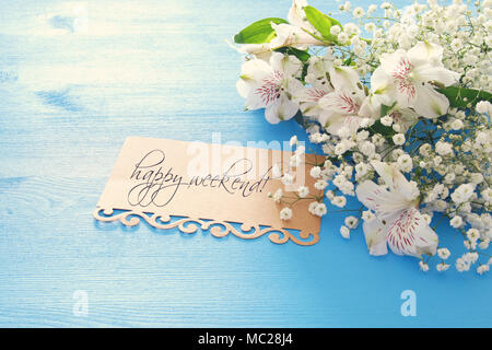 Vista superiore del bianco di splendidi fiori la disposizione e la lettera blu su sfondo di legno Foto Stock