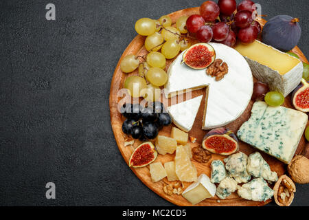 Formaggio Brie su una tavola di legno con fichi e uva Foto Stock