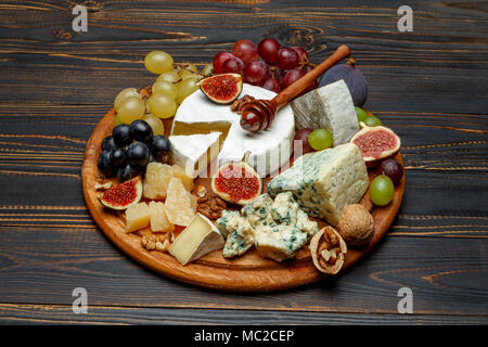 Formaggio Brie su una tavola di legno con fichi e uva Foto Stock