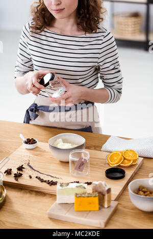 Close-up di una persona la produzione di cosmetici naturali con agrumi, formaggio bianco e chiodi di garofano Foto Stock