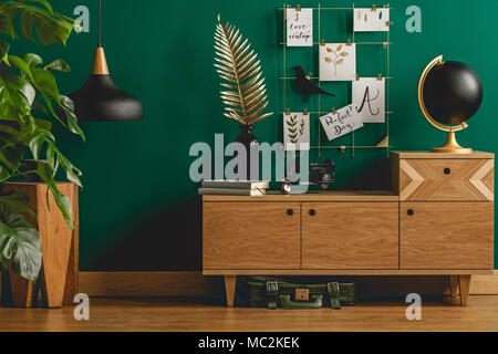 Verde scuro interno dell appartamento con stile scandinavo con arredi di legno e designer nero e decori in oro Foto Stock