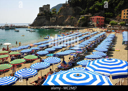 Simmetrico righe di blu e bianchi ombrelloni su di una spiaggia di sabbia, Monterosso al Mare in Italia Foto Stock