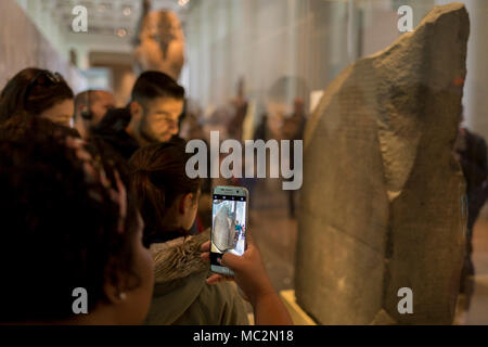 Ai visitatori di ammirare la Rosetta Stone nella sala 4 del British Museum, il 11 aprile 2018, a Londra, in Inghilterra. Foto Stock