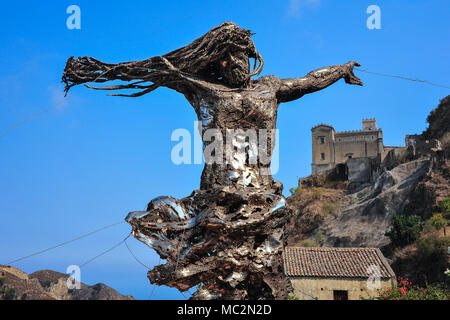 La scultura di Cristo domina il paesaggio dove il blu del cielo e del mare si incontrano, con la città medievale in background. Creato da un artista locale Antonino Ucchino Foto Stock