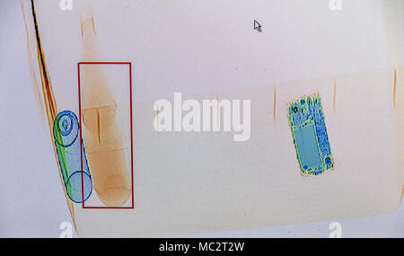 X-ray screenshot di un sacchetto con, da sinistra a destra : un flacone spray, una bottiglia di acqua e uno smartphone. Foto Stock