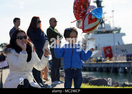 Hiroko Johnson, e il figlio di Kobe, attende per salutare il marito Petty Officer 1a classe di Michael Johnson che staziona sul Guardacoste Stratton come il coltello ritorna alla sua homeport in Alameda, California, a seguito di una quasi due mese lungo counternarcotic pattugliamento nell'Oceano Pacifico orientale, Gennaio 28, 2018. Il suo equipaggio interdetto cinque sospetti di contrabbando di droga navi durante la pattuglia risultante nel sequestro di oltre 12.000 libbre di cocaina per un valore stimato di $ 165 milioni all'ingrosso. Stati Uniti Coast Guard foto di Aux. David Lau. Foto Stock