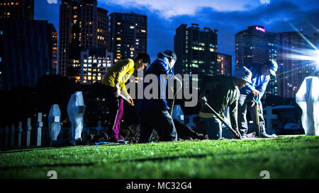 Lavoratori locali con la Commissione di Monumenti di Combattimento americana lavorare con i membri della difesa POW/mia agenzia di contabilità (DPAA) durante un disinterment a Manila American Cemetery a Manila nelle Filippine, 22 gennaio 2018. Il disinterment era parte di DPAA fatica a identificare le incognite persa durante la seconda guerra mondiale e di fornire il più possibile completa di contabilità il nostro personale mancante per le loro famiglie e per la nazione. (U.S. Marine Corps Photo by Staff Sgt. Demetrio Munnerlyn) Foto Stock