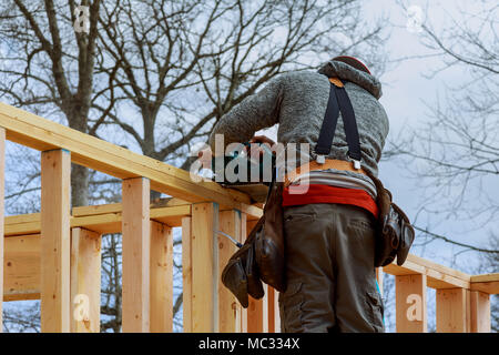 Costruttori sulla superficie di lavoro utilizzando una sega circolare di taglio edificio di legno contro il telaio Foto Stock