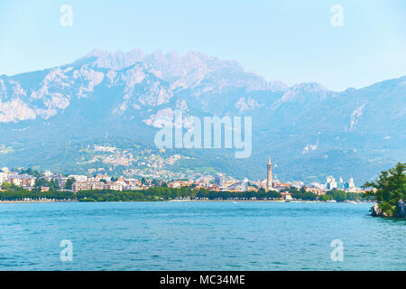 Bella estate della vista della città di Lecco in Italia sulla riva del lago di Como con visibile il campanile della chiesa di San Nicolò Foto Stock