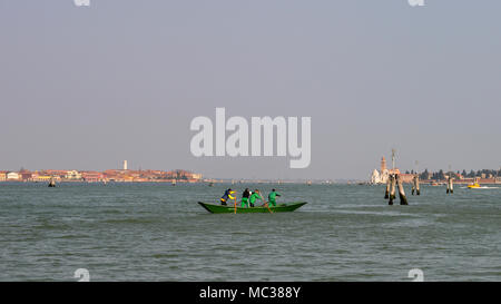 I rematori in laguna di Venezia con l'isola di Murano in background Foto Stock