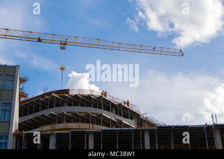 Crane and construction workers. Workers on multi-story building. Foto Stock