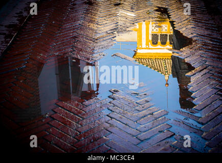 La riflessione di Rosina balcone (El Balcón de Rosina) in una pozza in Santa Cruz dopo la pioggia nella città spagnola di Siviglia, in Andalusia, Spagna Foto Stock