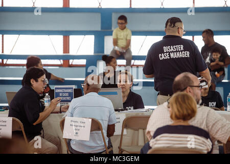 Fajardo, Puerto Rico, 15 marzo 2018 - Membri del disastro la gestione del caso assistere un superstite durante il Disaster Recovery equa delle risorse in Fajardo. One Stop Shop evento fornisce informazioni e assistenza necessaria ai superstiti, e ciò consente loro di recuperare dagli effetti dell'Uragano Maria.Le fiere si svolgono in tutta Puerto Rico dove del governo federale e statale, insieme con il settore privato, forniscono indicazioni circa la prevenzione di preclusione, alloggiamento di consulenza, servizi legali, alluvione di assicurazione, mitigazione, titolo e altri problemi. Per ulteriori informazioni chiamate il (817) 372-0852. Foto Stock