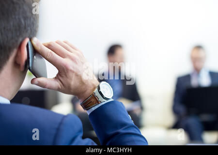 Team aziendale alla riunione di affari e il manager parlando al telefono. Foto Stock