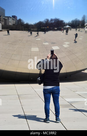 Una donna prende un selfie con Chicago's "fagiolo" nel Millennium Park in una calda giornata di primavera. Foto Stock