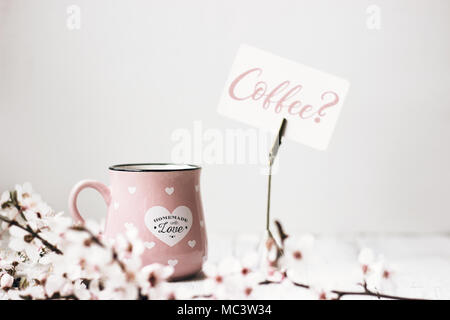 Rosa tazza da caffè, fiori di colore bianco e "caffè?' nota, su sfondo bianco Foto Stock