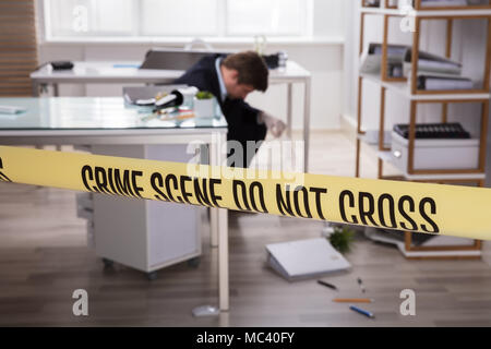 Close-up di giallo della scena del crimine in nastro anteriore investigatore della raccolta di elementi di prova Foto Stock