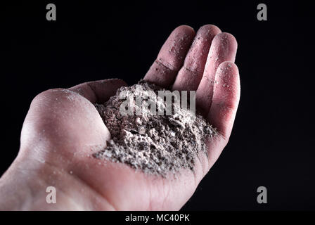 Persone mano azienda cenere grigia isolati su nero. Close up. Messa a fuoco selettiva Foto Stock