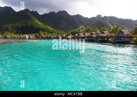 Vista verso una baia a Moorea, con turchesi acque tropicali & bungalows sul mare. Polinesia francese, South Pacific. Foto Stock