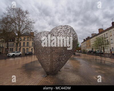 Troyes, Francia. Il 12 aprile, 2018. Tempo stagionale: un nuvoloso e umido del mattino seguita da un pomeriggio soleggiato nella città di Troyes, Francia. La scultura di 'Le coyeur de Troyes' (il cuore di Troyes). "Cuore della città" è costituito da più di duecento pezzi di 40x40 cm in acciaio inossidabile assemblati insieme. Credito: James Bell/Alamy Live News Foto Stock