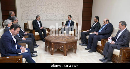 Damasco, Siria. Xii Apr, 2018. Il Presidente siriano Bashar al-Assad (4th, R) parla con Ali Akbar Velayati (5th, R), un senior advisor all'Iran il leader supremo Ayatollah Ali Khamenei, in Damasco Capitale della Siria, il 12 aprile 2018. Il Presidente siriano Bashar al-Assad detto il giovedì che la minaccia degli Stati Uniti di colpire la Siria sarà ulteriormente destabilizzare la regione, stato news agency sana segnalati. Credito: Presidenza siriano/Xinhua/Alamy Live News Foto Stock