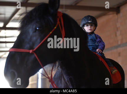 Un bambino a cavallo durante l'equino-terapia assistita (Mangiare) in Stritez, nella Repubblica ceca il 11 aprile 2018. Il DORADO civic society aiuta i bambini disabili per 25 anni. (CTK foto/Lubos Pavlicek) Foto Stock