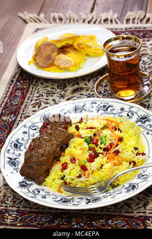 Cucina iraniana, persiano jeweled riso e pollo fesenjan, patata tahdig Foto Stock