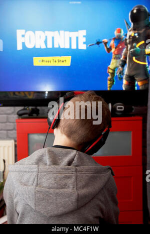 Un bambino gioca Fortnite Battle Royale sulla sua Xbox uno Foto Stock