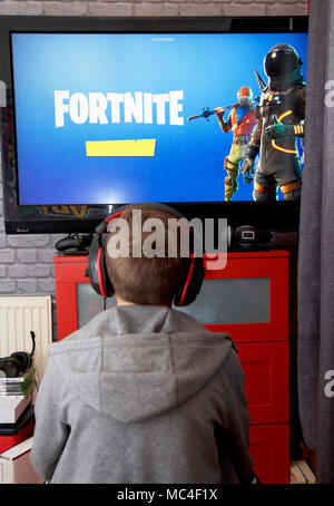 Un bambino gioca Fortnite Battle Royale sulla sua Xbox uno Foto Stock