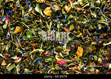 La texture del tè verde con secchi petali di fiori blu, calendula, fiordaliso. Sfondo di cibo. Organici a base di erbe salutari foglie, detox tea. Foto Stock
