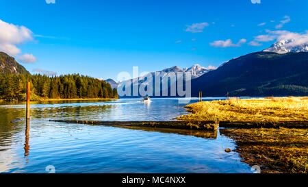 Barca da pesca la voce di Pitt lago con le cime innevate del Golden Ears, Tingle di picco e altre vette delle Coast Mountains Foto Stock