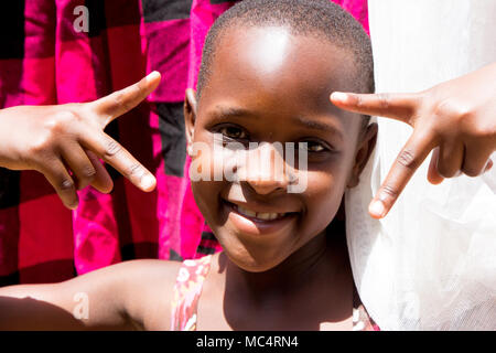 Lugazi, Uganda. 14 maggio 2017. Un ritratto di una bella ragazza ugandese tra l'asciugatura di biancheria. Foto Stock