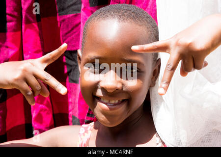 Lugazi, Uganda. 14 maggio 2017. Un ritratto di una bella ragazza ugandese tra l'asciugatura di biancheria. Foto Stock