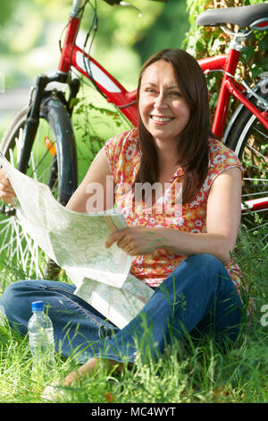 Ritratto di donna matura sul tragitto in bicicletta in campagna Mappa di lettura Foto Stock