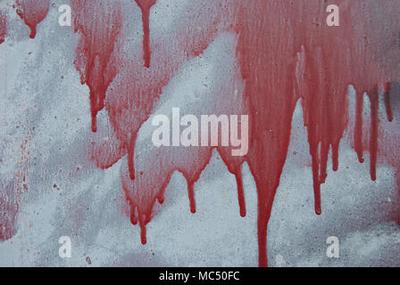 I flussi di olio rosso di vernice sul muro grigio della casa Foto Stock