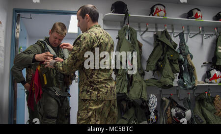 (Da sinistra) U.S. Air Force Capt. James Broncheau, tredicesima Fighter Squadron F-16 Fighting Falcon pilota, rimuove il volo con ingranaggio guida dalla U.S. Navy Petty Officer 2a classe Julio Gonzalez, un attacco elettronico Squadron (VAQ) 134 equipaggi equipmentman sopravvivenza, dopo un EA-18G Growler familiarizzazione volo a Misawa combatté Air Base, Giappone, Gennaio 18, 2018. VAQ-134, di stanza al di fuori del Naval Air Station Whidbey Island, Washington, era a Misawa combatté dal settembre per una routine di distribuzione di rotazione all'interno della regione e sono volato con F-16s su una base settimanale. (U.S. Air Force photo by Staff Sgt. Silvano Heitzman) Foto Stock