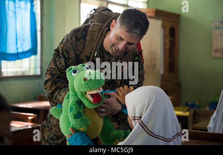 180406-N-OU129-025 BENGKULU, Indonesia (Aprile 06, 2018) Lt. Lee Atkinson, da Yuma, Ariz., dimostra la salute dentale delle pratiche per gli studenti di SDN 77 Scuola Elementare di Bengkulu, Indonesia durante il partenariato del Pacifico 2018 (PP18). PP18's missione è lavorare collettivamente con host e nazioni partner per migliorare l'interoperabilità a livello regionale di emergenza e capacità di risposta, aumentando la stabilità e la sicurezza nella regione e favorire la nascita di nuove e durature amicizie in tutta la regione Indo-Pacifico. Pacific Partnership, ora nel suo tredicesimo iterazione, è la più grande multinazionale annuale assistanc umanitario Foto Stock