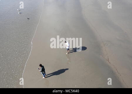 Preso da Santa Monica Pier guardando in giù su due persone sulla spiaggia al di sotto di Foto Stock