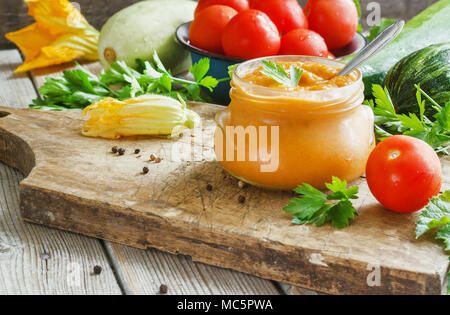 Squash pasta di zucchine in un barattolo di vetro circondato da gli ingredienti. Foto Stock