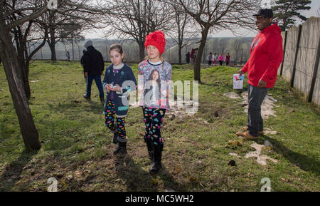 DEVESELU, Romania (28 marzo 2018) Master-at-Arms di prima classe Cavaliere Marshall, assegnato al supporto navale Facility Deveselu, aiuta i bambini da scuola Deveselu, una locale scuola rumena, trovare le uova di pasqua durante una comunità relazioni (COMREL) progetto. NSF Deveselu AAMDS e Romania sono co-localizzato con il rumeno 99th Base Militare e gioca un ruolo chiave nel missile balistico di difesa in Europa orientale. Foto Stock