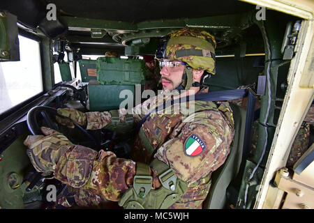 Un esercito italiano paracadutista assegnato al reggimento "Savoia Cavalleria" Folgore Brigata Grosseto, condurre attività di formazione con elevata mobilità multiuso di veicolo su ruote (HMMWV) assistenza egress trainer (calore), a Caserma Ederle Vicenza, Italia, 29 marzo 2018. Il simulatore consente ai soldati di pratica uscire dai veicoli, di competenze e di impegnarsi in scenari realistici. I paracadutisti italiani utilizzare U.S. RTSD esercito sud attrezzatura per migliorare le relazioni bilaterali e per espandere i livelli di cooperazione e la capacità del personale coinvolto nelle operazioni congiunte. Foto Stock