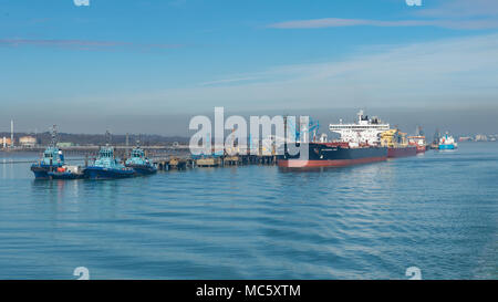 Navi e rimorchiatori attraccata ad un molo vicino Fawley raffineria di petrolio Foto Stock