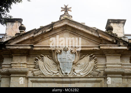 In pietra scolpita Stemma e croce di malta sopra l'entrata dei Cavalieri Ospitalieri Chiesa, Valletta, Malta Foto Stock