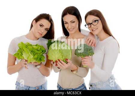 Tre belle donne azienda savoia, lattuga e broccoli isolati su sfondo bianco Foto Stock