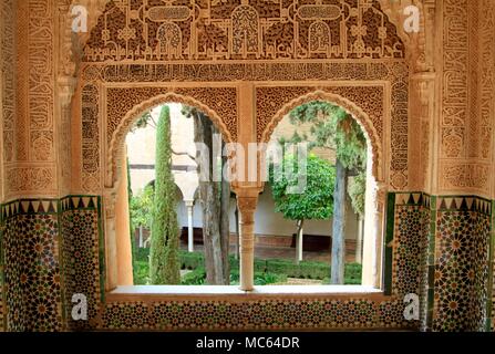 Intricati intarsi in pietra dettagli circostanti il ferro di cavallo finestre ad arco dell'Alhambra Palace, Granada, Spagna Foto Stock