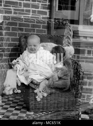 AJAXNETPHOTO. 1910 (circa). Posizione sconosciuta. - FAMILY SNAPSHOT - giovane bambino nella sedia di vimini che posano per una fotocamera con un muro di mattoni; doppio EXPOURE, immagine difettosa. fotografo:sconosciuto © IMMAGINE DIGITALE COPYRIGHT VINTAGE AJAX Picture Library Fonte: AJAX FOTO VINTAGE COLLEZIONE REF:181004 05 Foto Stock