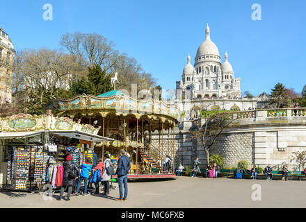 Un turista famiglia è guardare il negozio di souvenir visualizzato vicino alla giostra di Louise Michel park al di sotto della basilica del Sacro Cuore di Parigi. Foto Stock