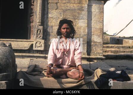 Uomini santi. Contorting Fakir del suo corpo nel difficile yogic pone. Katmandu Foto Stock