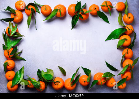 Orange tangerini (arance, mandarini, clementine, agrumi) con foglie verdi su sfondo chiaro, copia dello spazio. Banner con copia spazio per il vostro Foto Stock